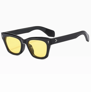 Detail of vintage cat-eye sunglasses with yellow lenses and silver rivets on black frames