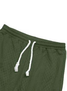 Close-up of men's dark green jacquard joggers featuring white drawstring and waffle texture