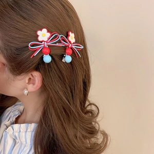 Detail showing floral leather bow hair clips with heart pendant on wavy brown hair