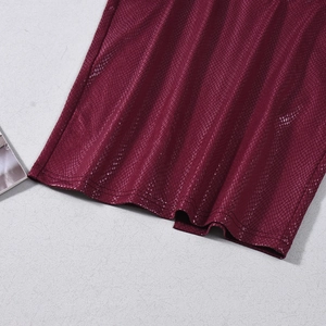 Detail shot of the faux snake skin texture and hem stitching on a burgundy dress
