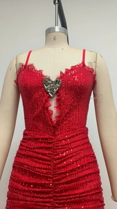 Macro shot of red sequin dress featuring heart metal buckle, lace trim and pleated details