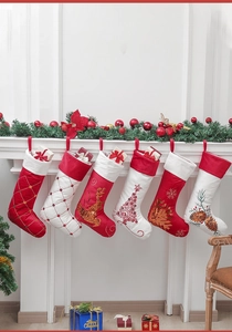 Details von roten und weißen Plüsch-Weihnachtssocken mit Pailletten am Kamin