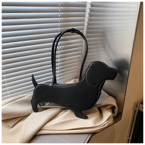 Macro shot of minimalist black sausage dog shaped tote bag showing leather texture