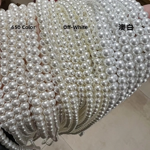 Macro detail of 6-8mm high-gloss round glass pearls in 650, creamy and Australian white