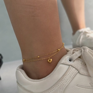 Double-layered golden stainless steel anklet with beads and heart charm on ankle