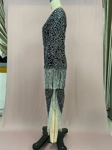 Detailed side view of black dress featuring silver sequins and double-layered fringe
