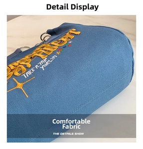 Detail shot of blue canvas tote bag showing high-quality fabric and yellow embroidery text
