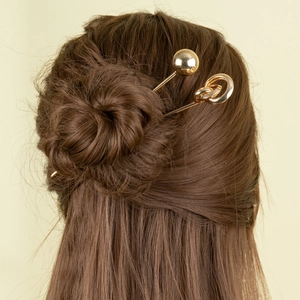 Minimalist metal hair stick set featuring gold ball and double ring designs in a bun
