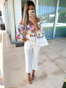 Close-up of floral off-shoulder puff sleeve top paired with white high-waist tied pants