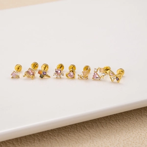 Close-up of golden stud earrings set featuring pink zircon butterflies and hearts