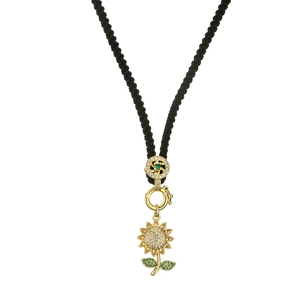 Gold sunflower pendant necklace with green crystals on a black cord chain, centered view