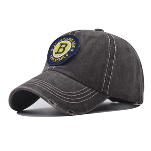 Detailed close-up of distressed brim and B embroidery on washed cotton baseball cap