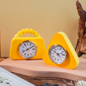 Yellow handbag and triangle desk clock set with Roman numerals on wooden decor
