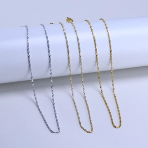 Macro detail of twisted water wave chain necklaces in silver, gold, and rose gold finishes