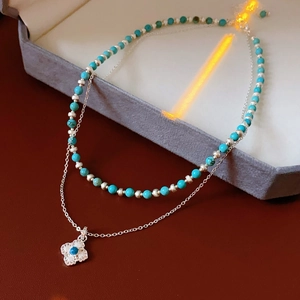 Detail of double-layer turquoise beaded necklace with sparkling clover pendant in velvet box