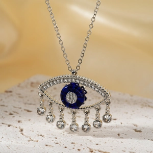 Silver evil eye pendant necklace with blue eye and white zircon dangles on stone