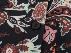 Detailed close-up of paisley pattern on woven fabric with a single black button