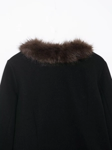 Close-up of the plush dark brown faux fur collar on a black stylish short jacket