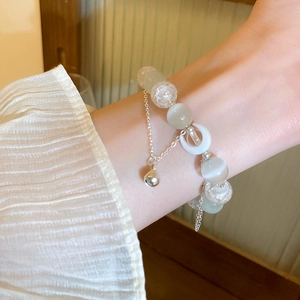 Detailed close-up of double-layer beaded bracelet with moon charm and cat eye stone