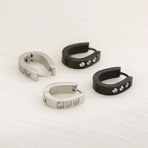 Détail de boucles d'oreilles en U en acier inoxydable noir et argent avec zircons blancs