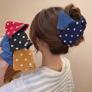 Polka dot fabric bow hair clip available in blue, red, black, and ginger yellow colors
