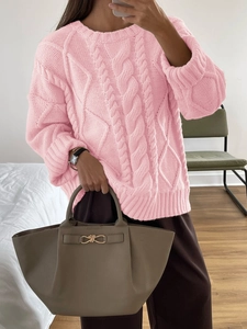 Close-up of pink cable knit sweater texture showing detailed thick weave for women