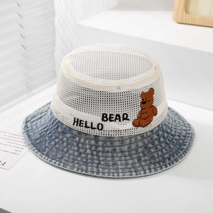 Detail of baby sun hat featuring white breathable mesh and blue denim bear embroidery