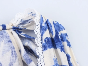 Vue détaillée du tissu tie-dye bleu et blanc avec dentelle blanche et bordure à franges