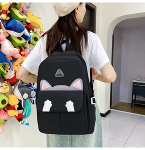 Detail view of the black cat-themed backpack featuring cute 3D ears and white paw prints