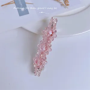 Elegant pink crystal beaded hair clip for women with sparkling faceted resin beads on white desk