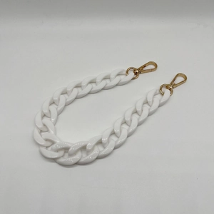 Close-up of white acrylic resin chain strap with polished gold lobster clasps