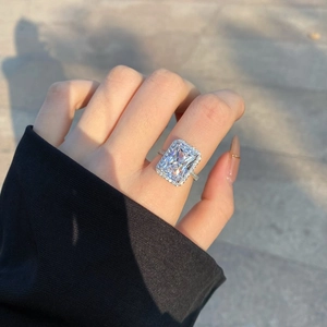 Macro detail of radiant cut square zircon halo ring showing sparkle on a woman's finger