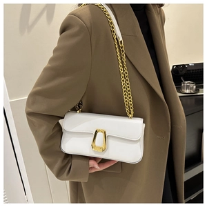 Minimalist white crossbody bag with gold chain strap and geometric clasp on model