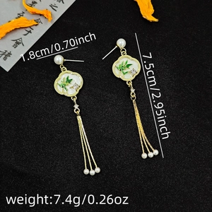 Macro detail of Chinese style tassel earrings with bamboo motifs and size measurements