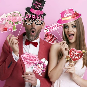 Valentine's Day photo booth props set with heart glasses and festive signs on pink background