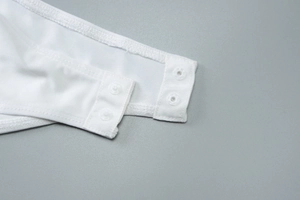 Détail des boutons-pression sur une robe bustier en tulle blanc à imprimé floral