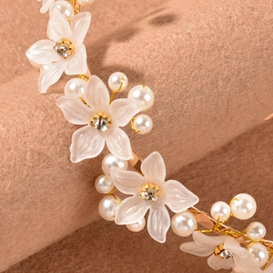 Elegant gold headband with frosted white flowers, pearls and rhinestones on beige velvet
