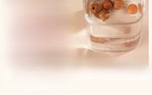 Macro view of high-density sandalwood beads showing oily texture and sinking in water