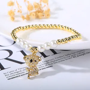 Close-up of pearl and gold bead bracelet with crystal-encrusted koala charm detail