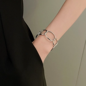 Close-up of polished silver metal chain link bracelet worn on a female wrist