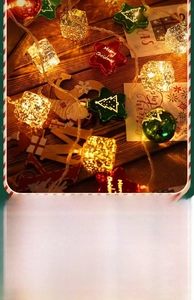 Detail of LED Christmas string lights featuring red stars and green trees on a wooden base