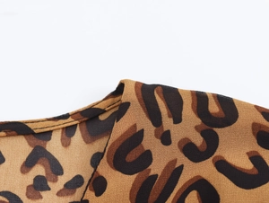 Close-up of V-neck stitching and leopard print texture on brown chiffon fabric