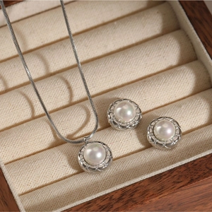 Elegant stainless steel necklace and earring set with pearls in a wooden jewelry box