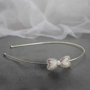 Dettaglio macro del cerchietto con fiocco di strass e perle bianche eleganti