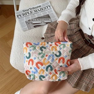 Detail of quilted cotton cosmetic bag with colorful patterns and Sozakka label