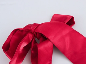 Gros plan détaillé d'un nœud en soie rouge brillant avec texture et nouage élégants