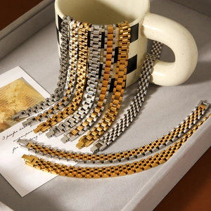 Detail of luxury watch-style bracelets in gold and silver steel on a gray velvet tray