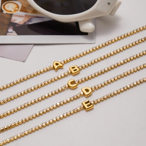 Elegante vergulde roestvrijstalen tennisarmband met fonkelende zirkonia letterhangers