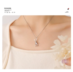 Detailed close-up of a silver mechanical rabbit pendant on a delicate bead chain