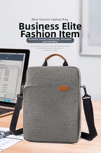 Detailed view of gray oxford fabric laptop bag on desk with brown leather handles